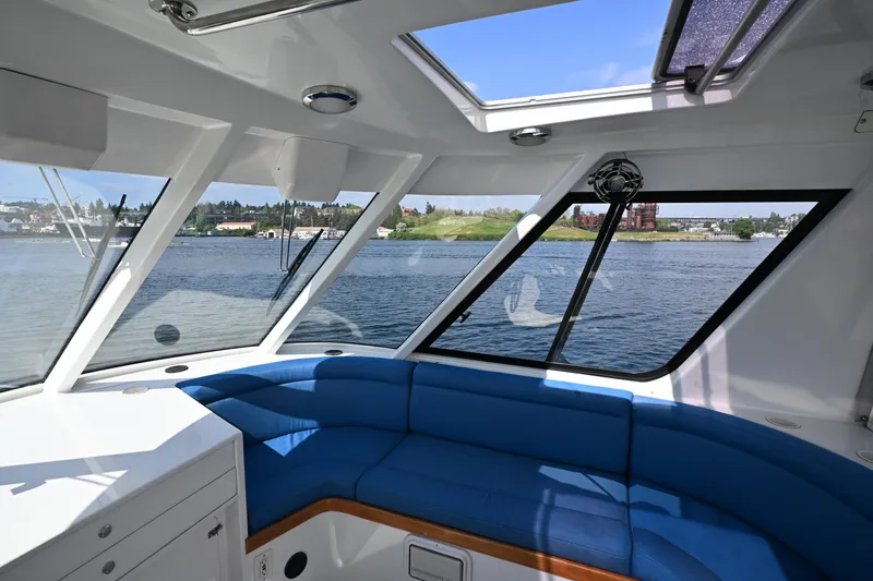 Slide: The Image of Interior view of 2002 Roger Hill Power Cat 41.4 with blue seating and waterfront scenery. - 24
