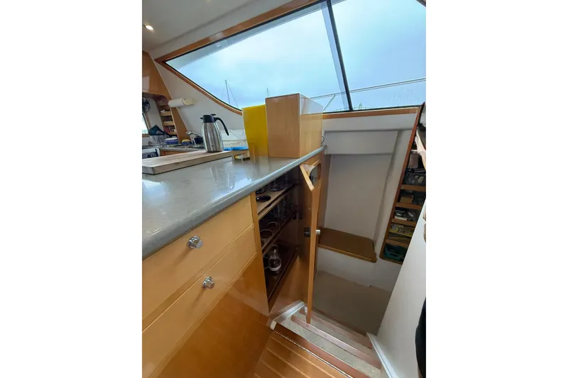 Slide: The Image of Interior of 2002 Norris Custom Motor Catamaran 41.4, featuring sleek kitchen and staircase. - 58