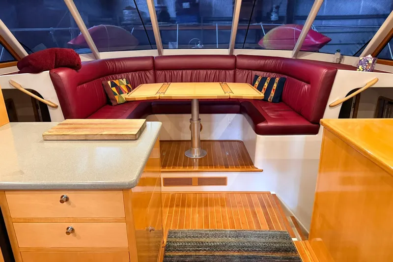 Slide: The Image of Luxurious interior of 2002 Norris Custom Motor Catamaran 41.4 with red leather seating and wooden accents. - 67
