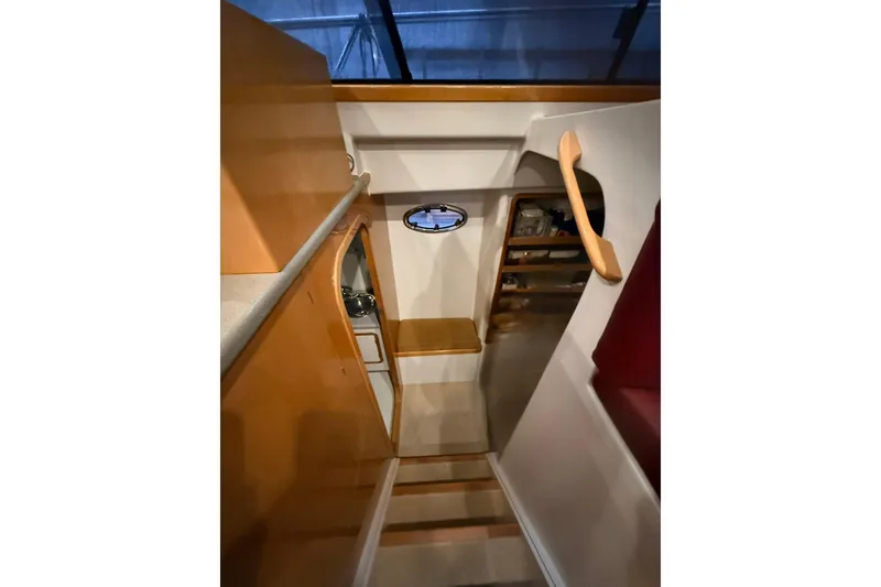 Slide: The Image of Interior of 2002 Norris Custom Motor Catamaran 41.4, featuring wooden cabinetry and porthole window. - 74