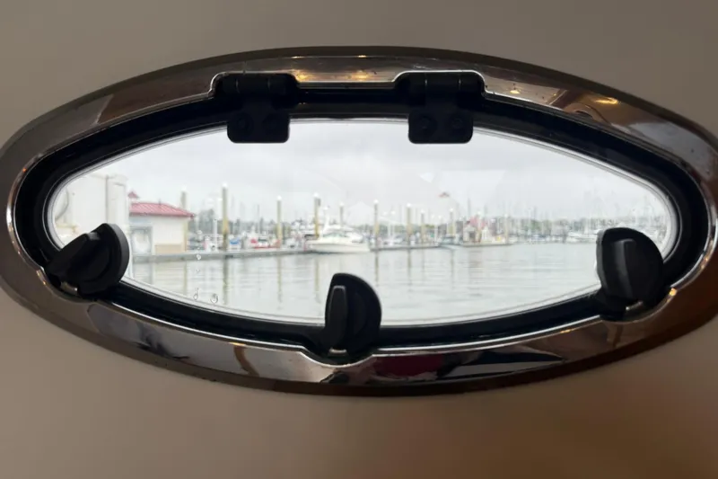 Slide: The Image of Oval porthole view from 2002 Norris Custom Motor Catamaran 41.4, overlooking marina. - 84