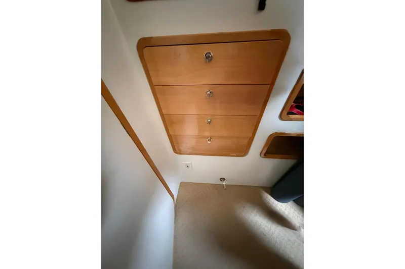Slide: The Image of Interior view of 2002 Norris Custom Motor Catamaran 41.4, featuring wooden drawers and carpeted flooring. - 98