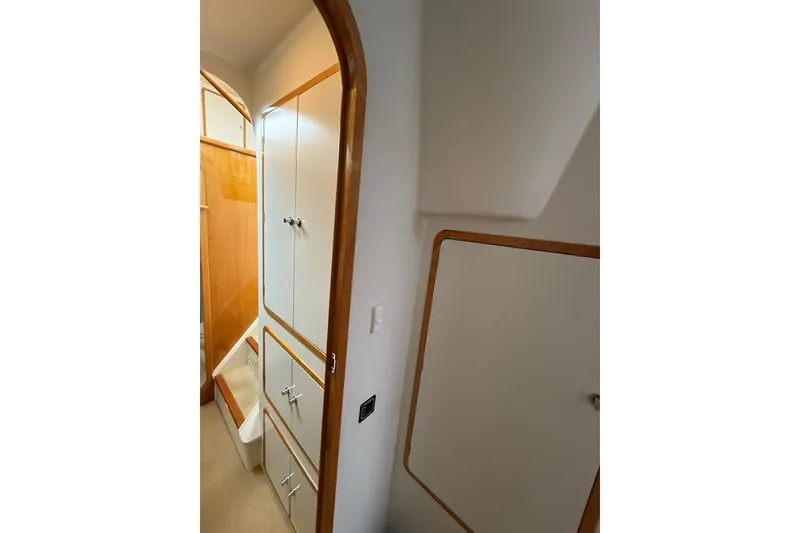 Slide: The Image of Interior of 2002 Norris Custom Motor Catamaran 41.4, featuring wooden cabinetry and white paneling. - 99