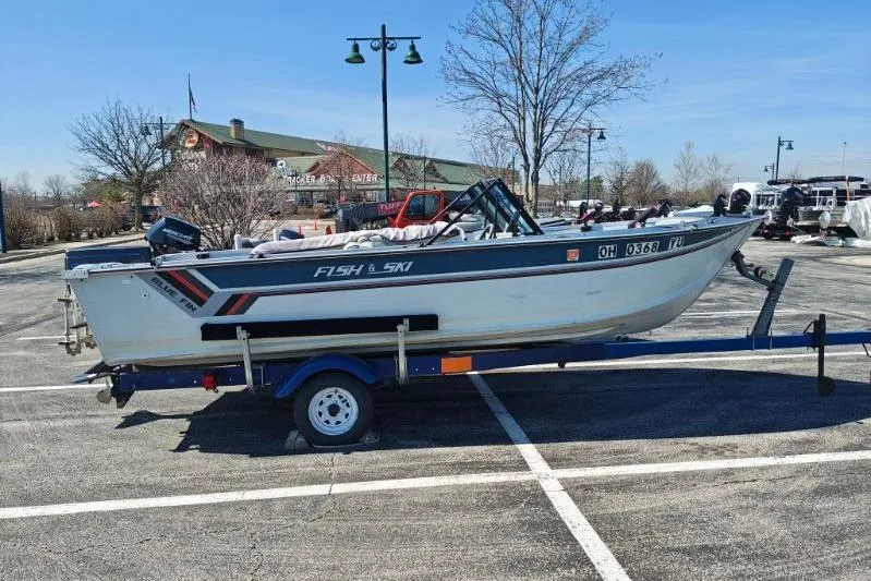 Slide: The Image of 1987 Blue Fin S170 boat on trailer in parking lot, clear sky background. - 5