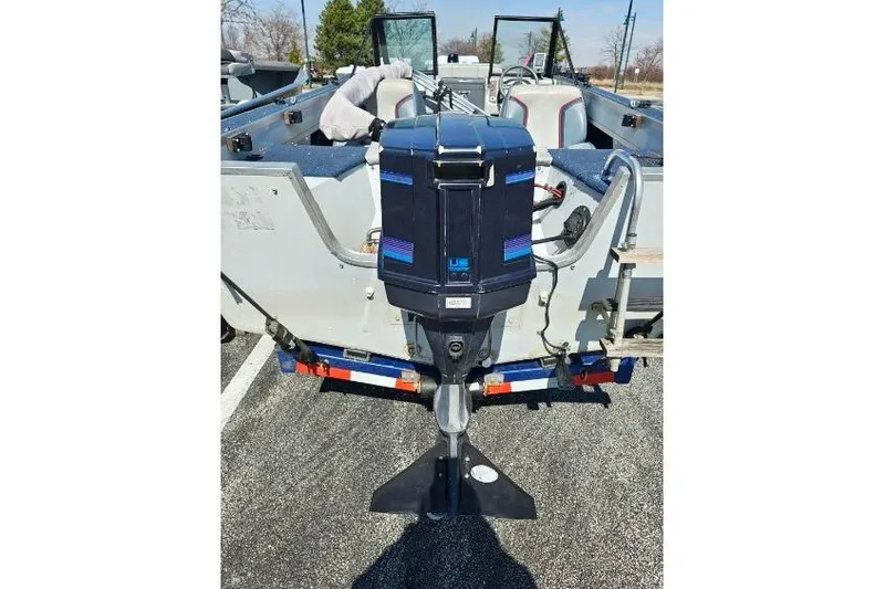 Slide: The Image of 1987 Blue Fin S170 boat with outboard motor, parked in a lot. - 7