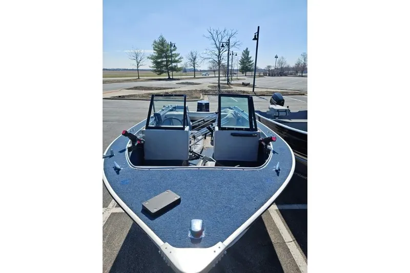 Slide: The Image of 1987 Blue Fin S170 boat with blue deck, parked in a lot under clear skies. - 8