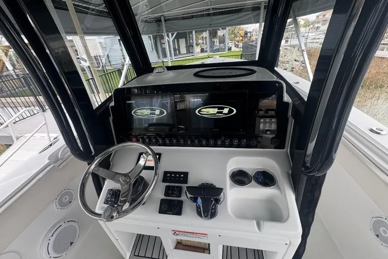 Slide: The Image of 2022 Sea Hunt Gamefish 27 Coffin Box helm with steering wheel and dual displays. - 10