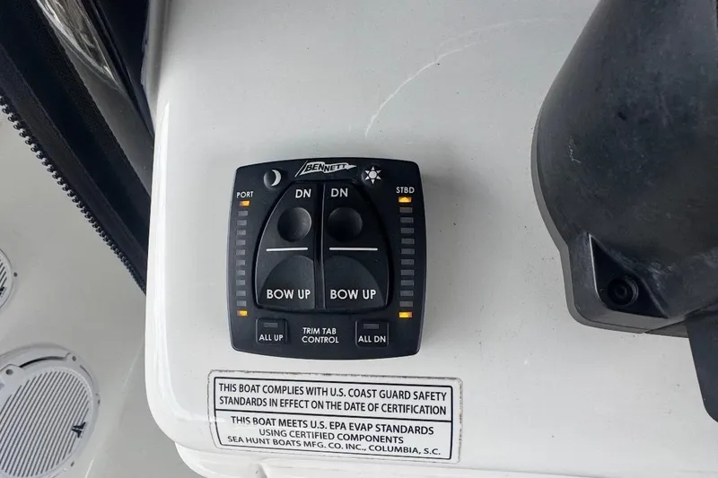 Slide: The Image of 2022 Sea Hunt Gamefish 27 Coffin Box trim tab control panel with safety compliance label. - 11
