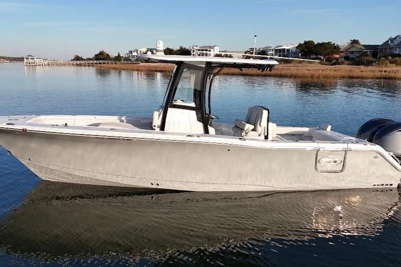 Slide: The Image of 2022 Sea Hunt Gamefish 27 Coffin Box boat on calm water, coastal background. - 3