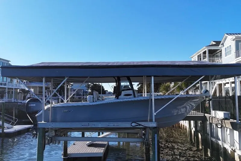 Slide: The Image of 2022 Sea Hunt Gamefish 27 Coffin Box boat docked under a canopy. - 5