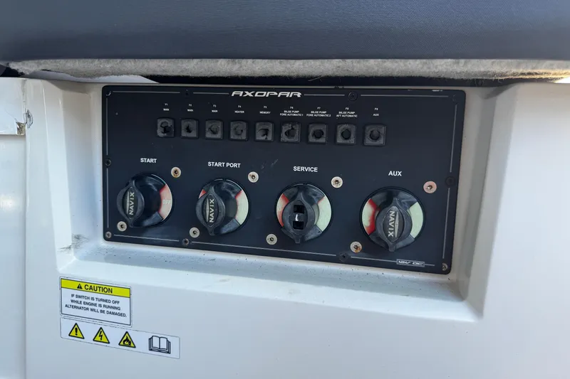 Slide: The Image of Control panel of a 2017 Axopar 37 Sun Top boat with switches and caution label. - 19