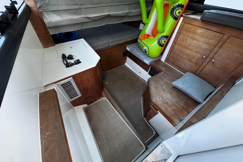 Slide: The Image of 2017 Axopar 37 Sun Top cabin interior with wood accents and inflatable toy. - 30