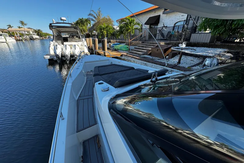 Slide: The Image of 2017 Axopar 37 Sun Top boat docked by waterfront property with lush greenery. - 33