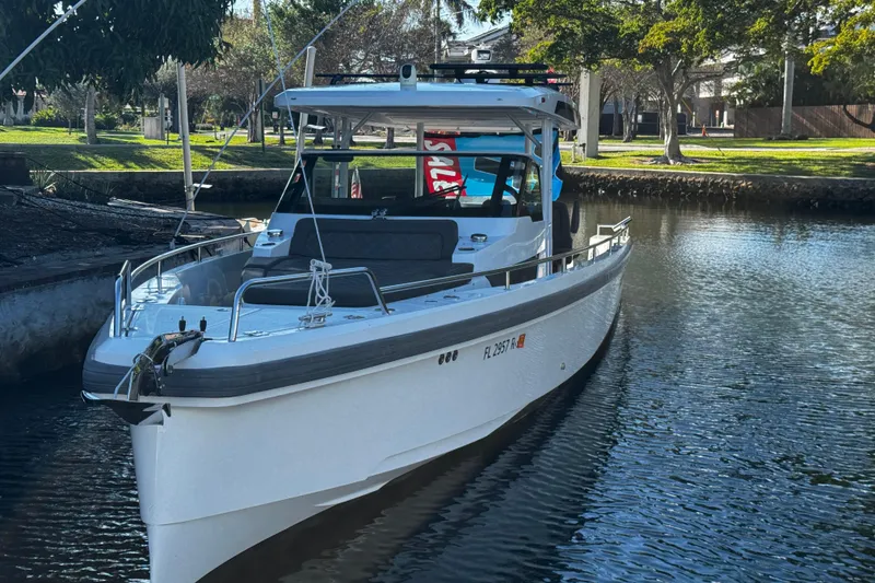 Slide: The Image of 2017 Axopar 37 Sun Top boat docked on a calm waterway. - 4