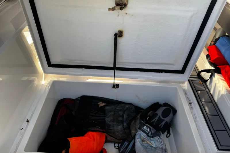 Slide: The Image of Open storage compartment on 2017 Axopar 37 Sun Top boat with life jackets and gear. - 44