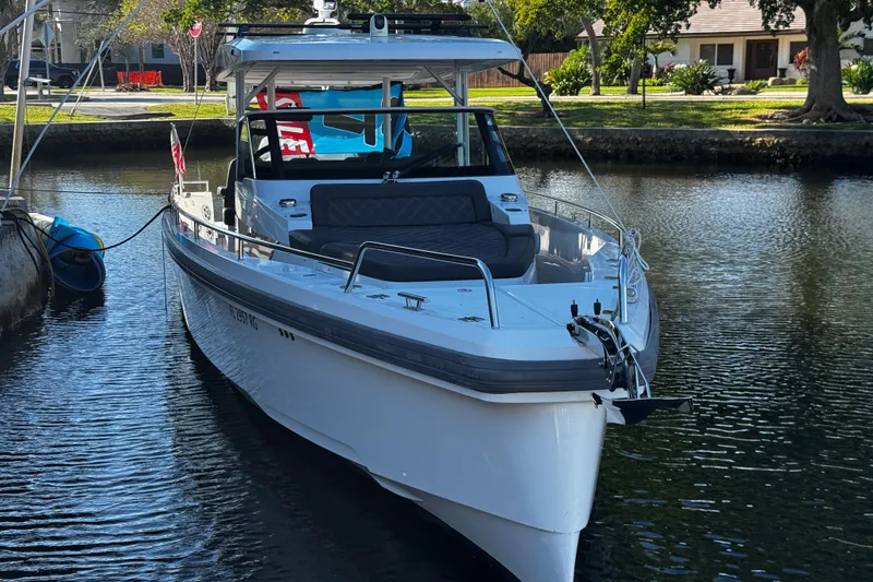 Slide: The Image of 2017 Axopar 37 Sun Top boat docked on a calm waterway. - 5