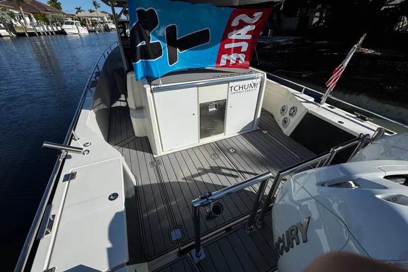 Slide: The Image of 2017 Axopar 37 Sun Top boat with sale flag, docked in a marina. - 8
