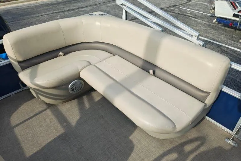 Slide: The Image of 2020 Sun Tracker Party Barge 18 interior seating with beige upholstery and speaker. - 10
