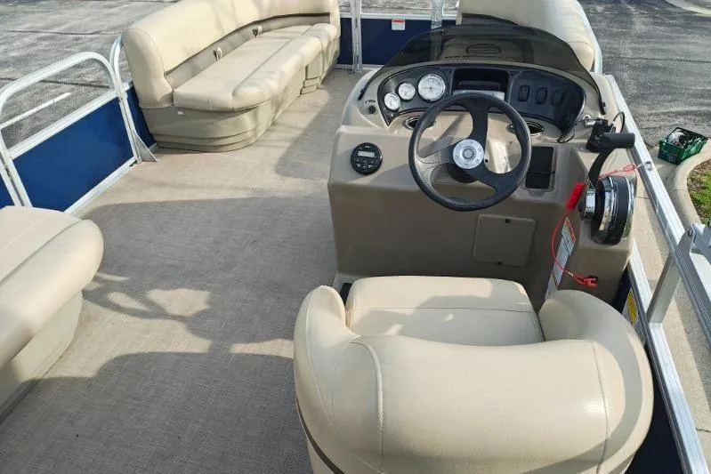 Slide: The Image of 2020 Sun Tracker Party Barge 18 interior with beige seating and steering console. - 13