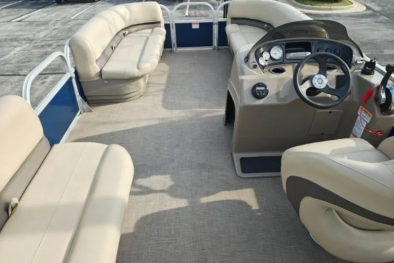 Slide: The Image of 2020 Sun Tracker Party Barge 18 interior with beige seating and steering console. - 14