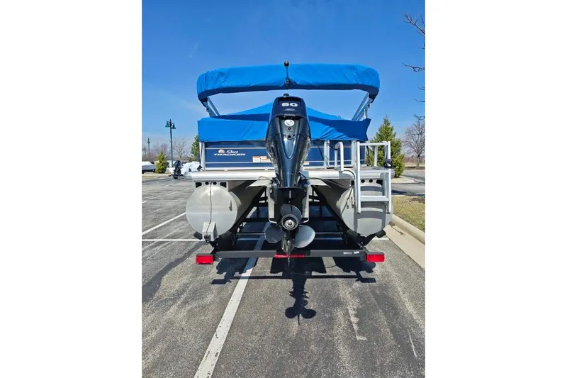 Slide: The Image of 2020 SUNTRACKER pb18 pontoon boat with blue canopy and outboard motor. - 3