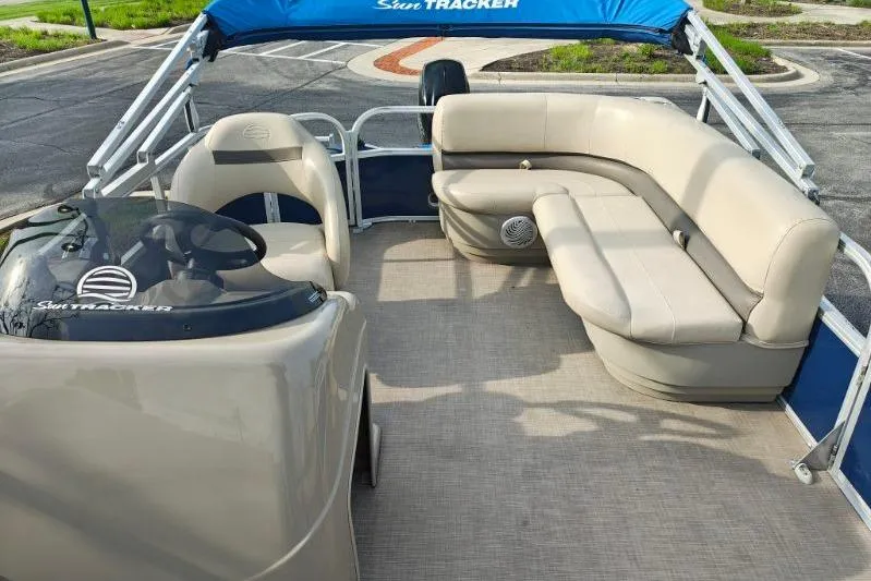 Slide: The Image of 2020 Sun Tracker Party Barge 18 pontoon boat with beige seating and blue canopy. - 9