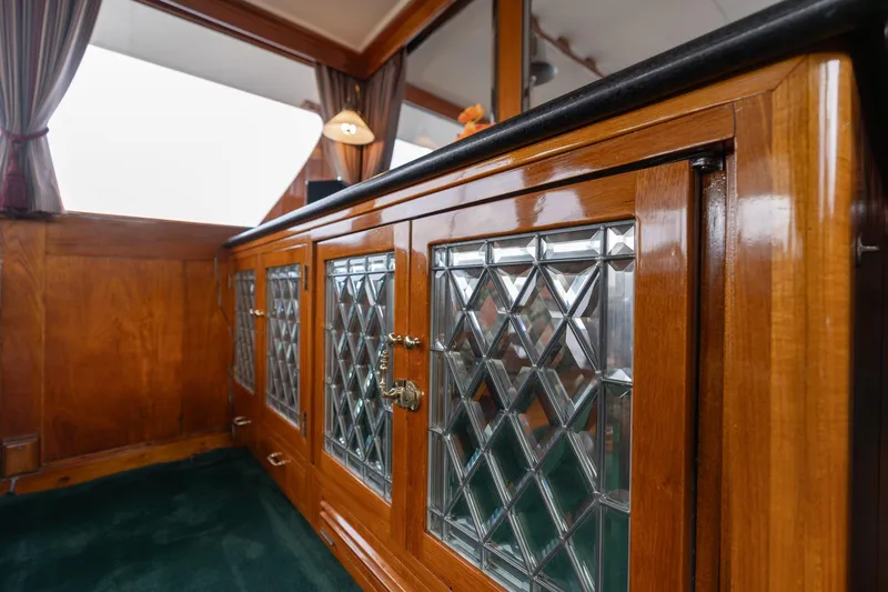 Slide: The Image of Elegant wooden cabinetry with glass panels inside a 1965 De Vries Lentsch 64 Motoryacht. - 25