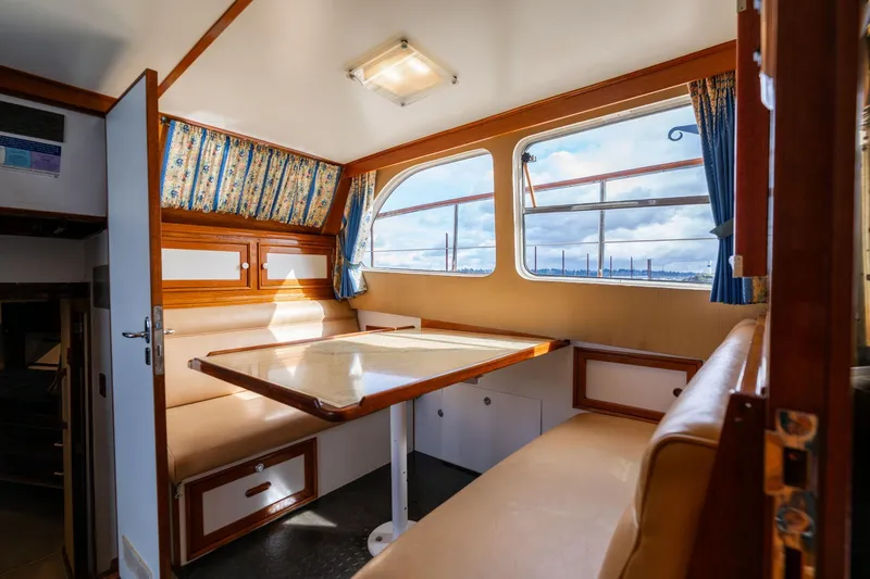 Slide: The Image of Interior of 1965 De Vries Lentsch 64 Motoryacht with cozy dining area and large windows. - 32