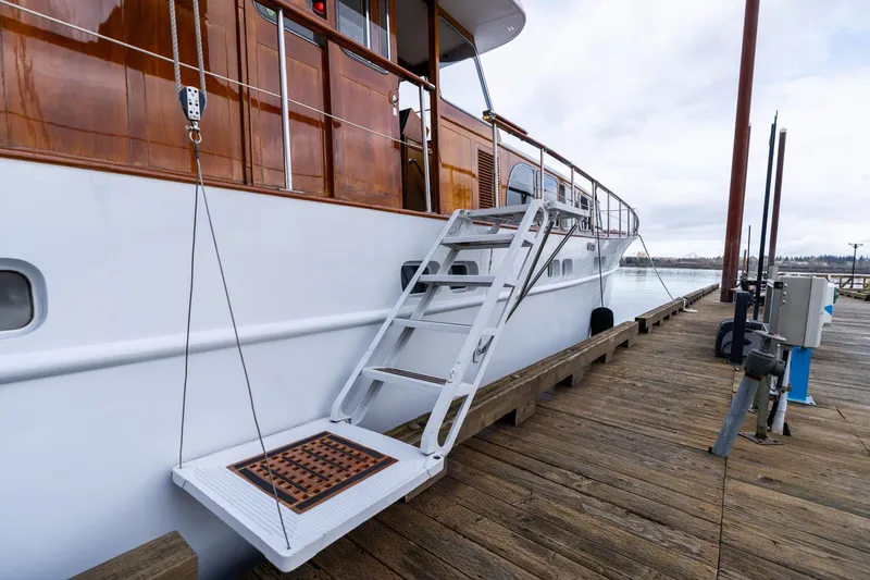 Slide: The Image of 1965 De Vries Lentsch 64 Motoryacht docked with wooden exterior and boarding ladder. - 6