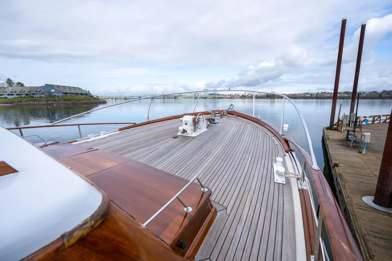Slide: The Image of De Vries Lentsch 64 Motoryacht 1965, elegant wooden deck, docked by serene waters. - 60