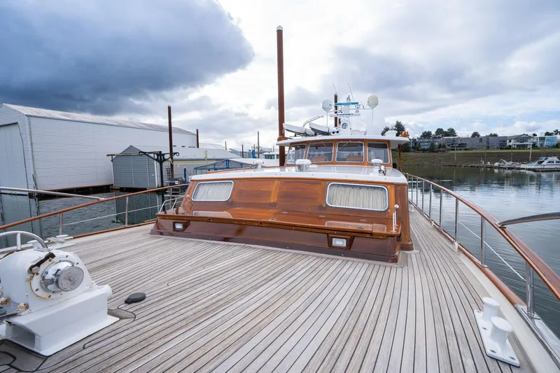 Slide: The Image of 1965 De Vries Lentsch 64 Motoryacht with wooden deck, docked under cloudy skies. - 64