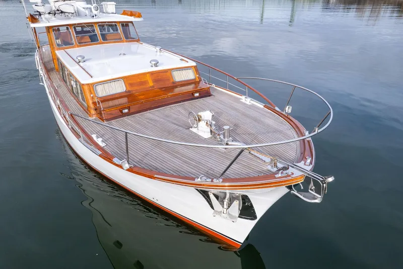 Slide: The Image of 1965 De Vries Lentsch 64 Motoryacht with wooden deck, docked on calm water. - 89