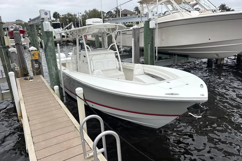 Slide: The Image of 2017 Regulator 28 boat docked at marina, featuring sleek white design and modern equipment. - 10