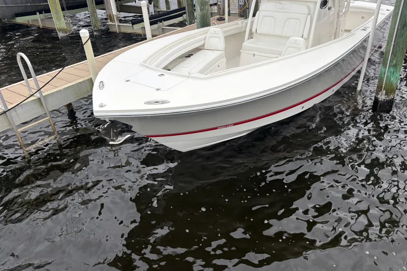 Slide: The Image of 2017 Regulator 28 boat docked on calm water, showcasing sleek design and white exterior. - 11