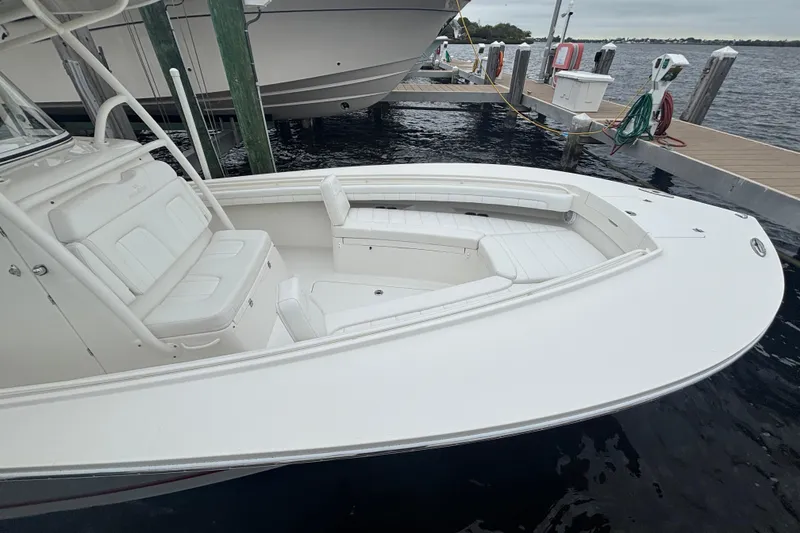 Slide: The Image of 2017 Regulator 28 boat docked, featuring spacious white seating and sleek design. - 12