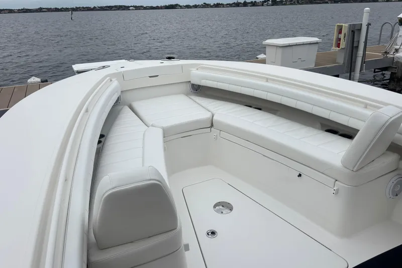 Slide: The Image of 2017 Regulator 28 boat with white cushioned seating, docked by the water. - 15