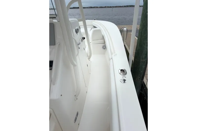 Slide: The Image of 2017 Regulator 28 boat interior with white deck and railing, docked by the water. - 18