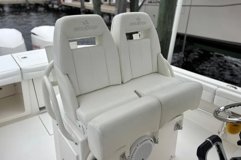 Slide: The Image of 2017 Regulator 28 boat with white cushioned seating and steering wheel. - 22