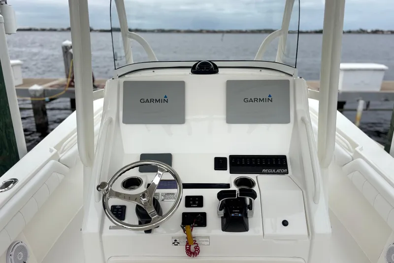 Slide: The Image of 2017 Regulator 28 boat helm with Garmin displays and steering wheel. - 23