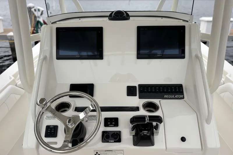 Slide: The Image of 2017 Regulator 28 boat dashboard with dual screens and steering wheel. - 24