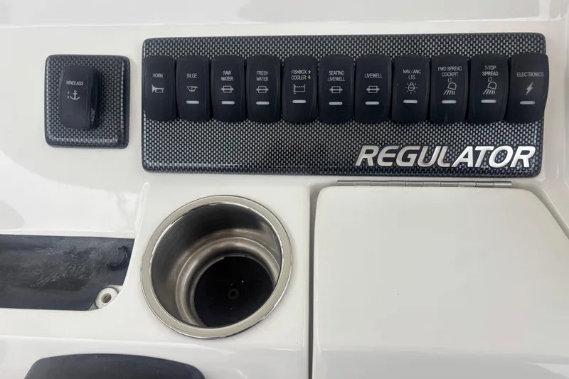 Slide: The Image of Control panel of a 2017 Regulator 28 boat with labeled switches and cup holder. - 34