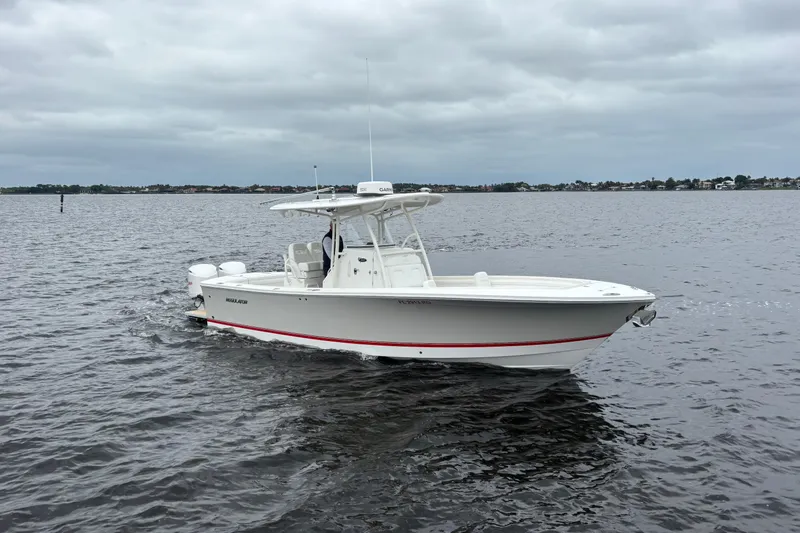 Slide: The Image of 2017 Regulator 28 boat cruising on a calm, overcast waterway. - 4