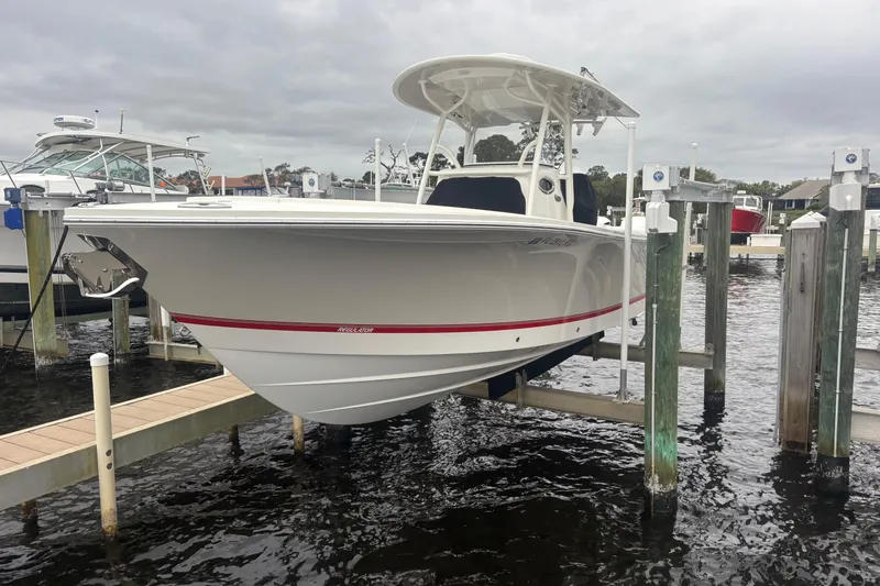 Slide: The Image of 2017 Regulator 28 boat docked on a lift, overcast sky, marina setting. - 44