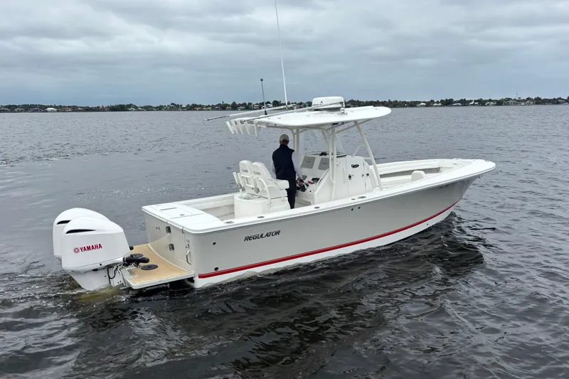 Slide: The Image of 2017 Regulator 28 boat with Yamaha engine on calm water under cloudy sky. - 6