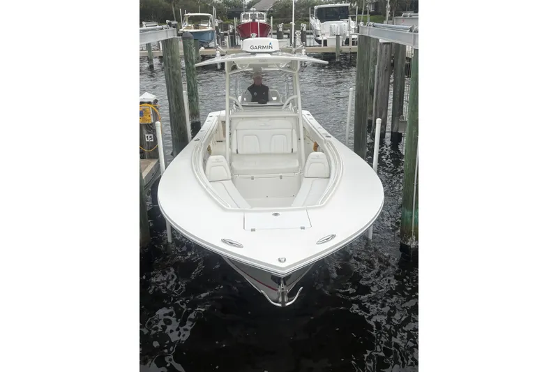 Slide: The Image of 2017 Regulator 28 boat docked, featuring a sleek white design and Garmin equipment. - 9