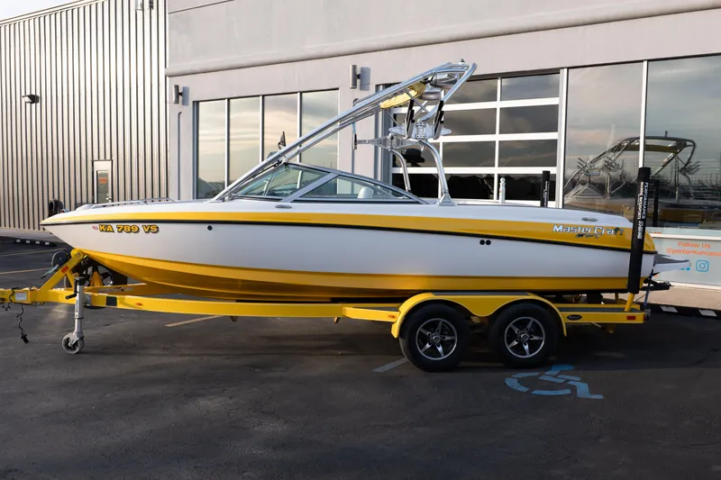 Slide: The Image of 2005 MasterCraft X10 boat in yellow and white on a trailer. - 2