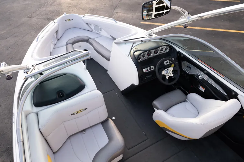 Slide: The Image of 2005 MasterCraft X10 boat interior with white and gray seating, dashboard, and steering wheel. - 21