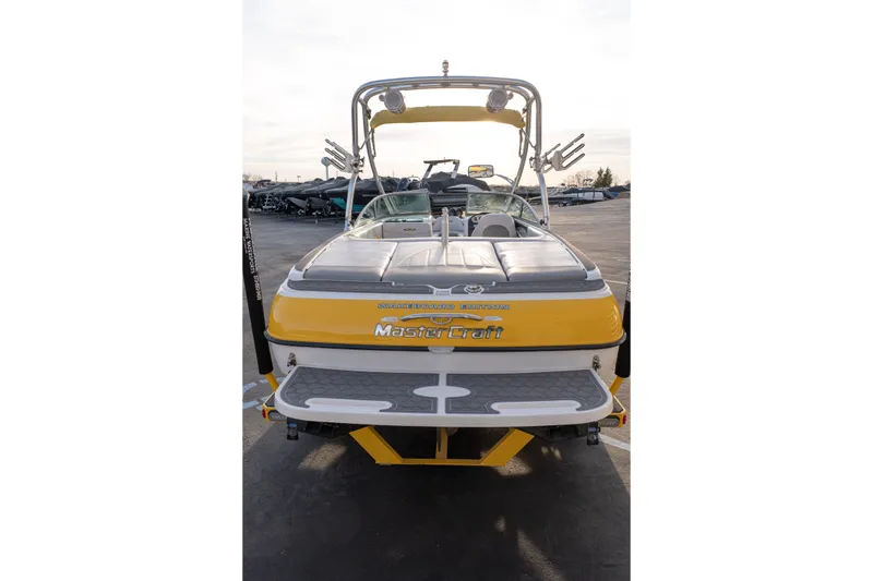 Slide: The Image of 2005 MasterCraft X10 wakeboard boat, yellow and gray, rear view in a parking lot. - 6