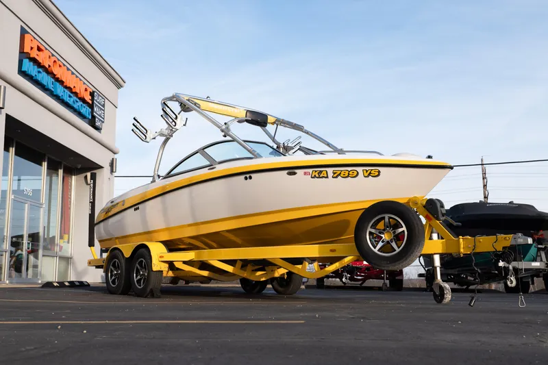 Slide: The Image of 2005 MasterCraft X10 boat on yellow trailer outside marine store. - 9