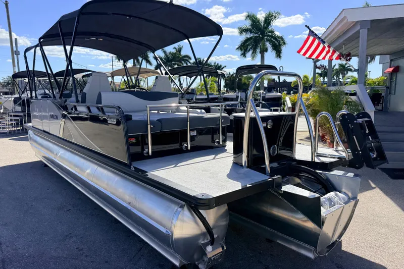 Slide: The Image of 2026 Avalon 2385 LSZ Versatile Rear Bench Tri Toon boat with canopy, parked outdoors. - 9